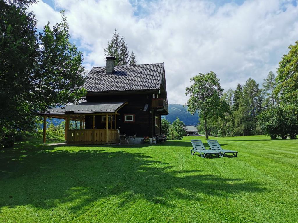 una casa con due sedie seduta sull'erba di Ferienhäuser Stohl a Mariapfarr