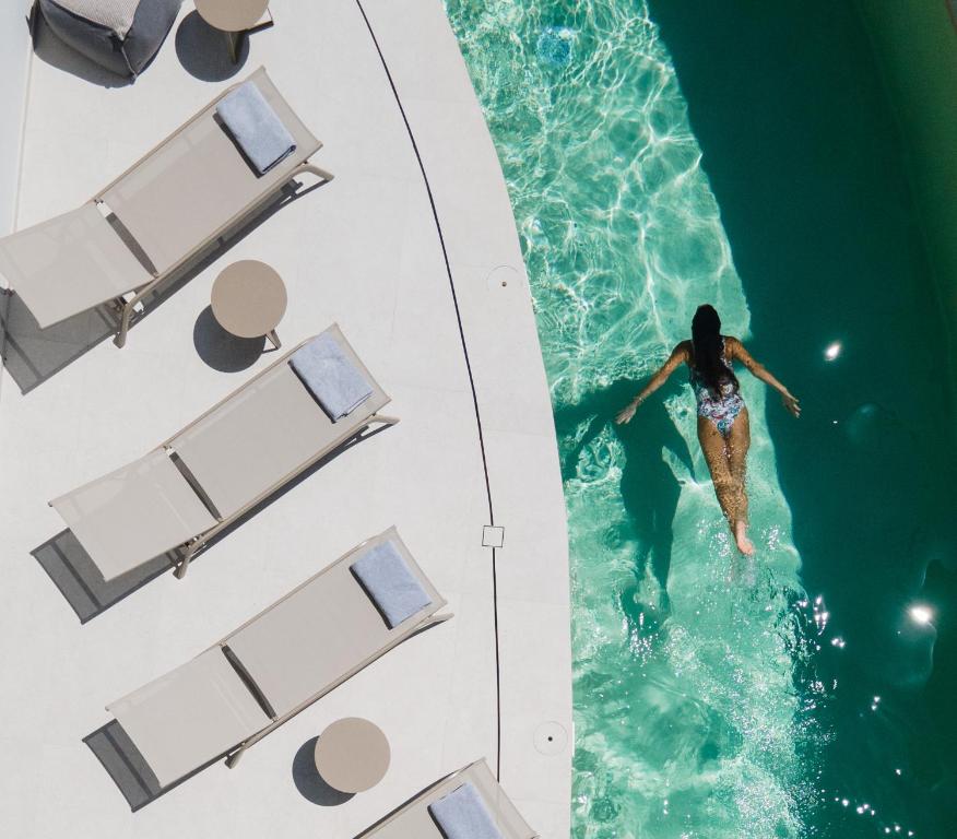 Eine Frau schwimmt im Pool in der Unterkunft Anapollo Boutique Hotel Adults Only in Naxos Chora