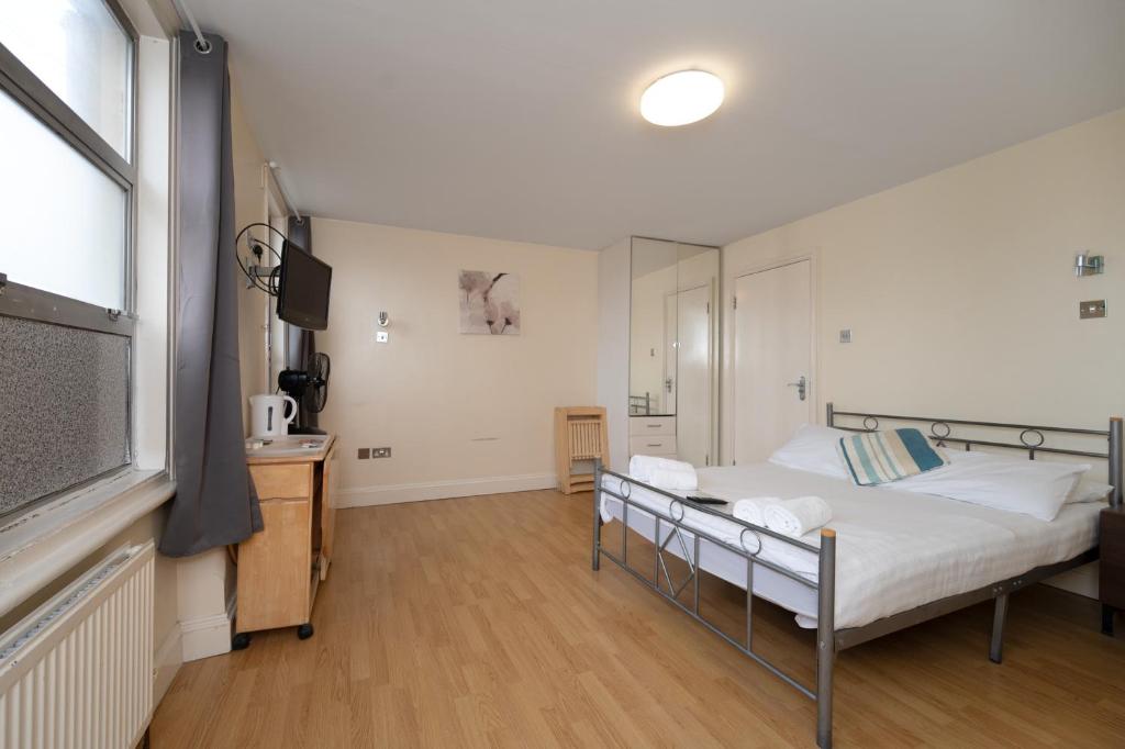ロンドンにあるFlexistay Aparthotel Tootingのベッドルーム(ベッド1台、テレビ付)