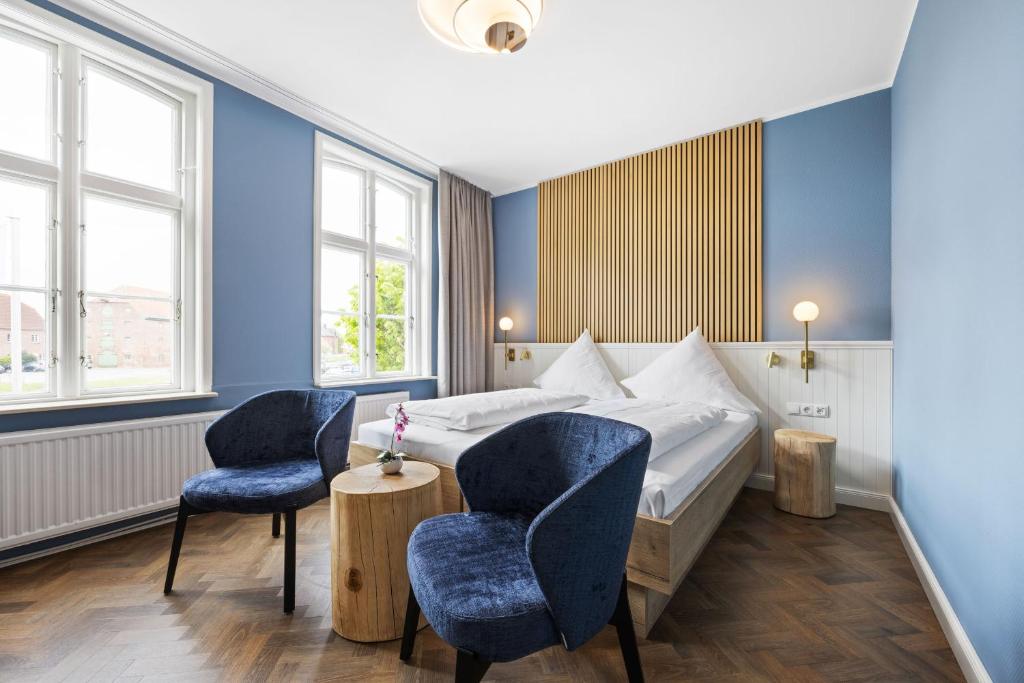 ein Hotelzimmer mit einem Bett und zwei Stühlen in der Unterkunft Zum Goldenen Anker in Tönning