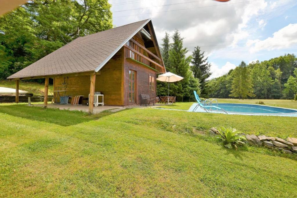 a log cabin with a pool in the yard at Apartma Šťastný III in Bechyně