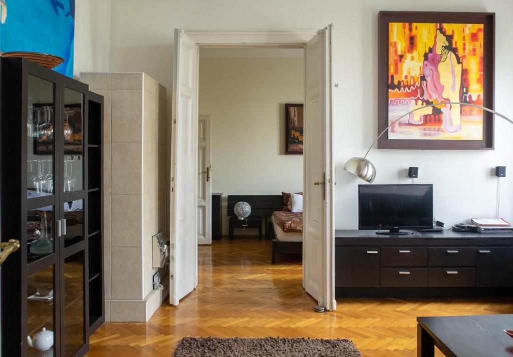a living room with a television on a dresser at d.Five Döbrentei Apartment in Budapest