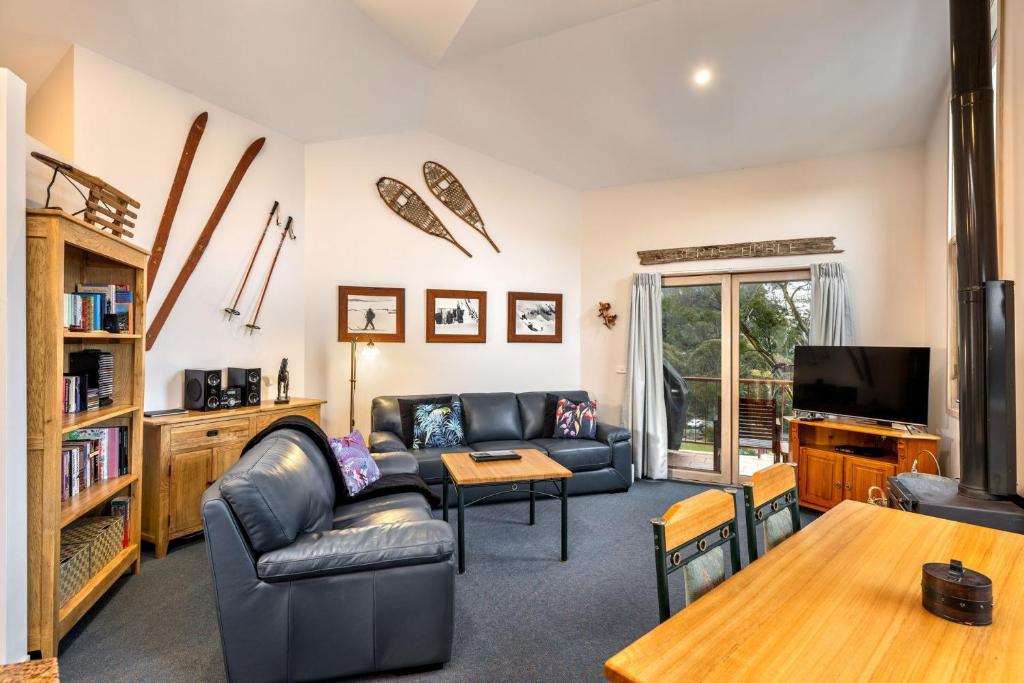 a living room with a couch and a table at Lhotsky 2 Bedroom with fireplace and sweeping mountain view in Thredbo