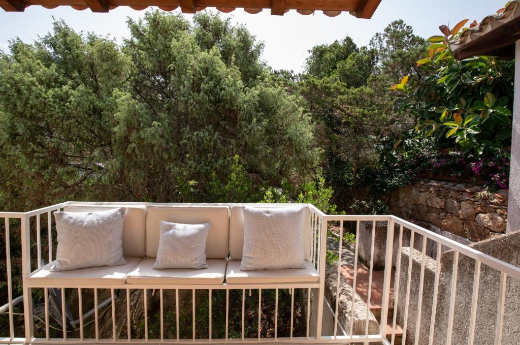 - un banc blanc avec 2 oreillers sur un balcon dans l'établissement Casa Neva by Wonderful Italy, à Porto Rotondo