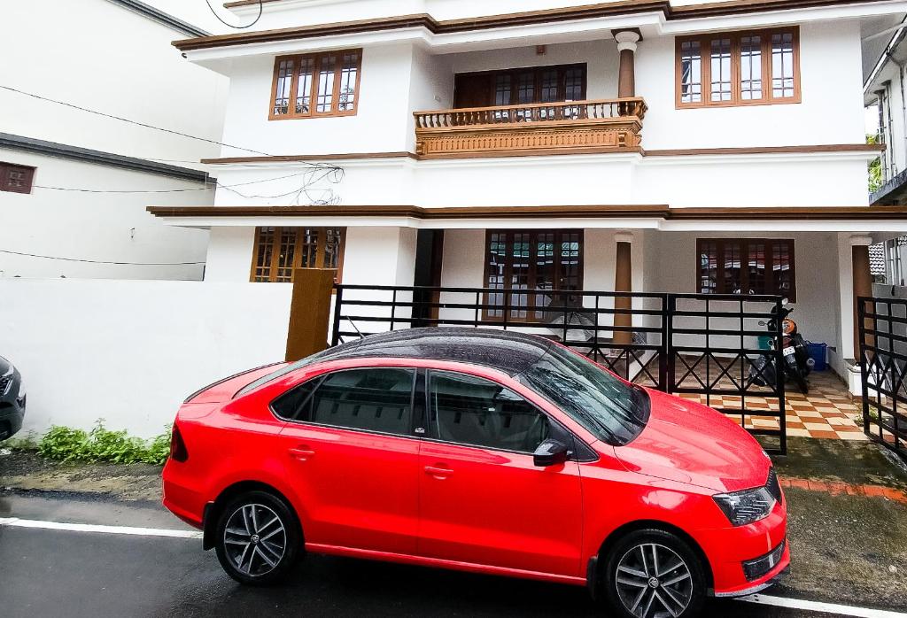 a red car parked in front of a house at 4BR AC House near Edappally Lulu Mall & AIMS Kochi in Ernakulam