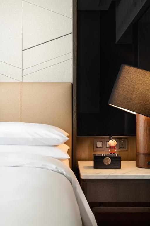西安市にあるRenaissance Xi'an Hotelのベッドルーム(ベッド1台、ランプ、テレビ付)