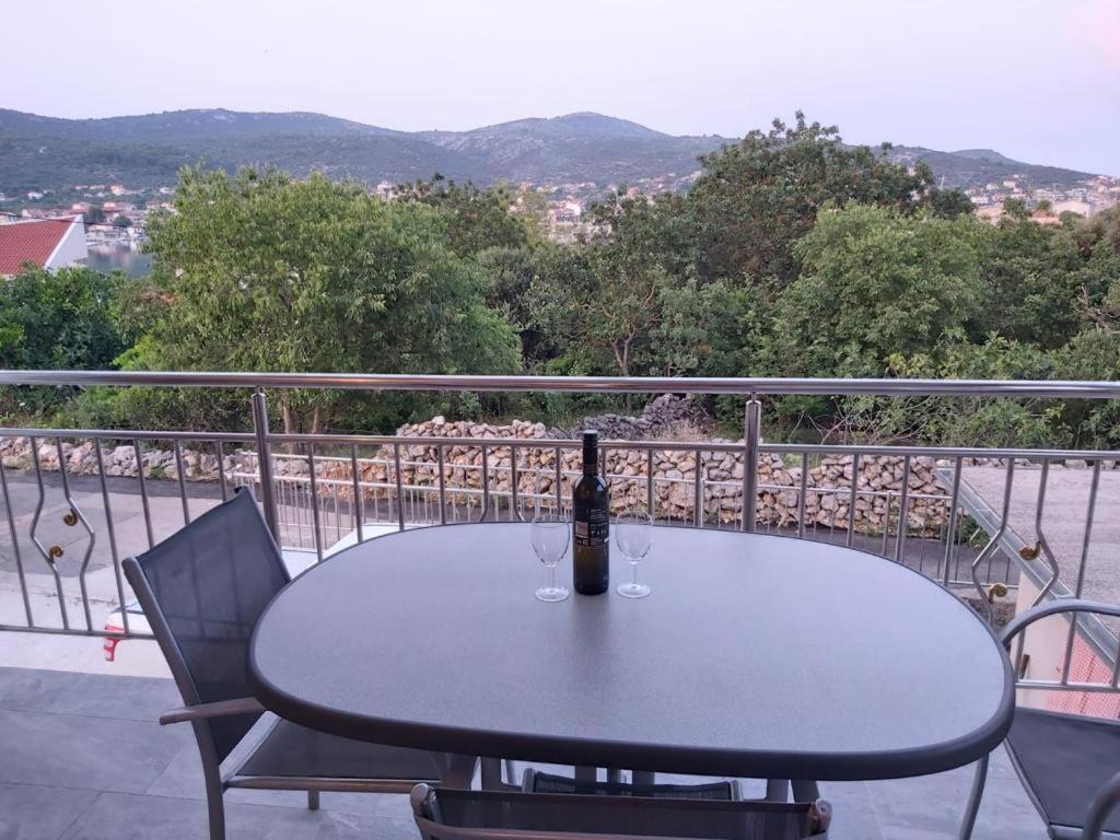 a bottle of wine sitting on a table on a balcony at Vila Nina - Apartment Valentina in Vinišće