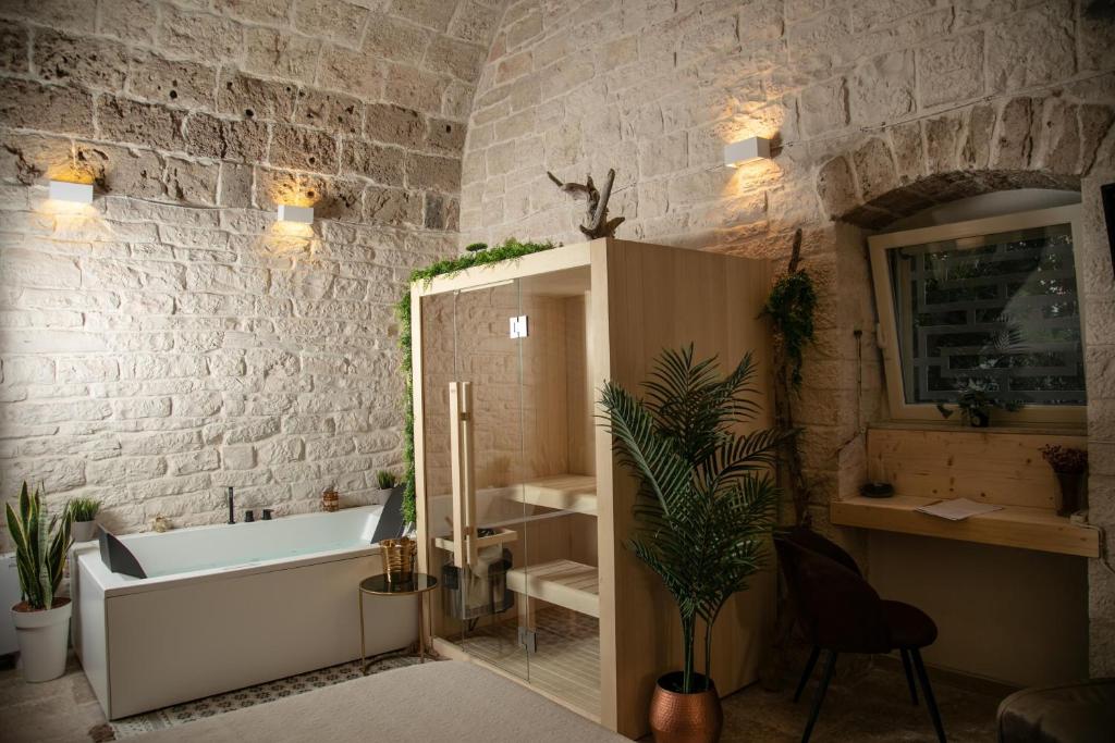 a bathroom with a tub and a stone wall at Alle volte Maison deluxe in Giovinazzo