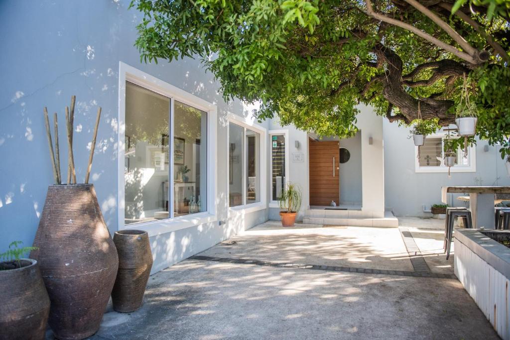a home with two large vases in front of a building at The Whale on Main B&B in Hermanus
