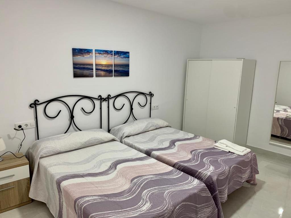 a bedroom with a bed and a picture on the wall at EL SOL ANDALUZ - CASA GOYA in Carboneras