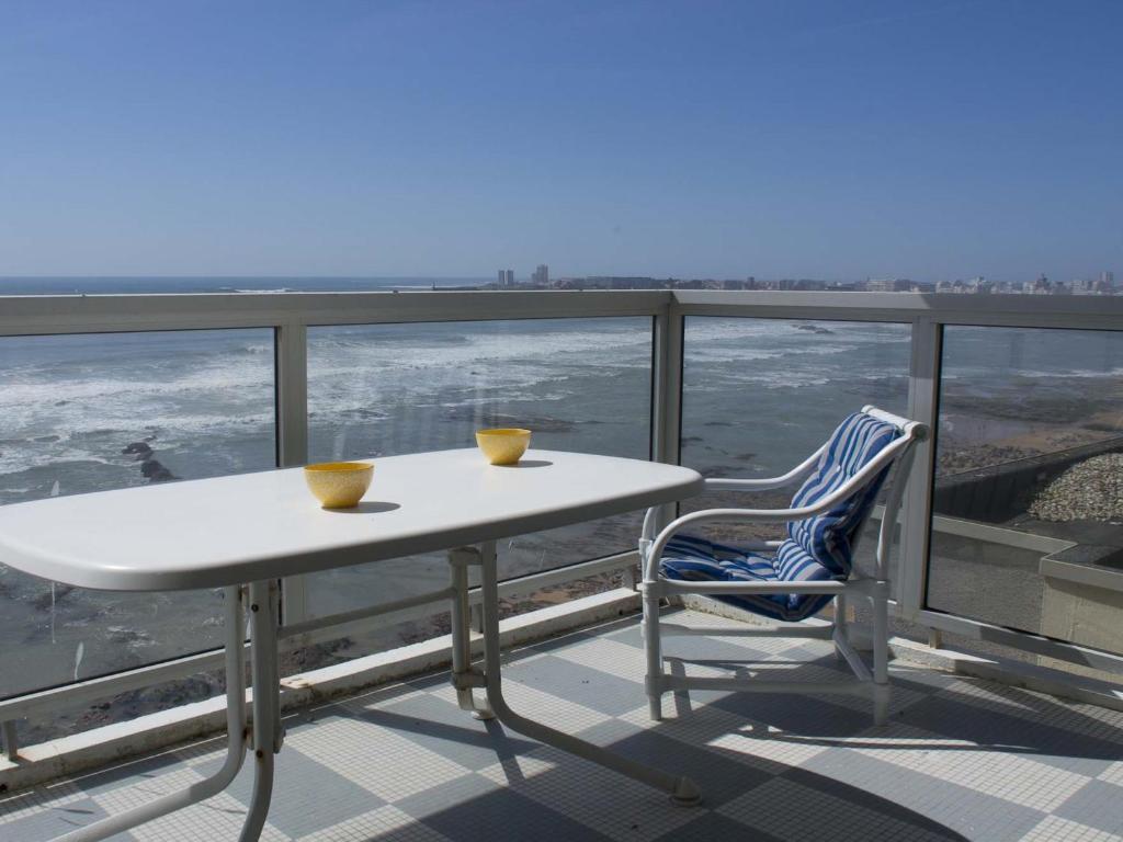 une table blanche et une chaise bleue sur un balcon dans l'établissement Appartement T3 lumineux, balcon sud, parking, proche plage et commerces - FR-1-92-688, à Les Sables-dʼOlonne