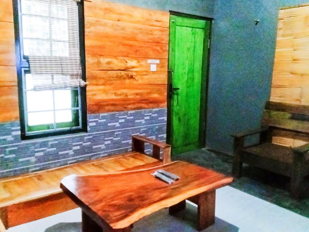a room with a table and a green door at Pine tree house in Jember