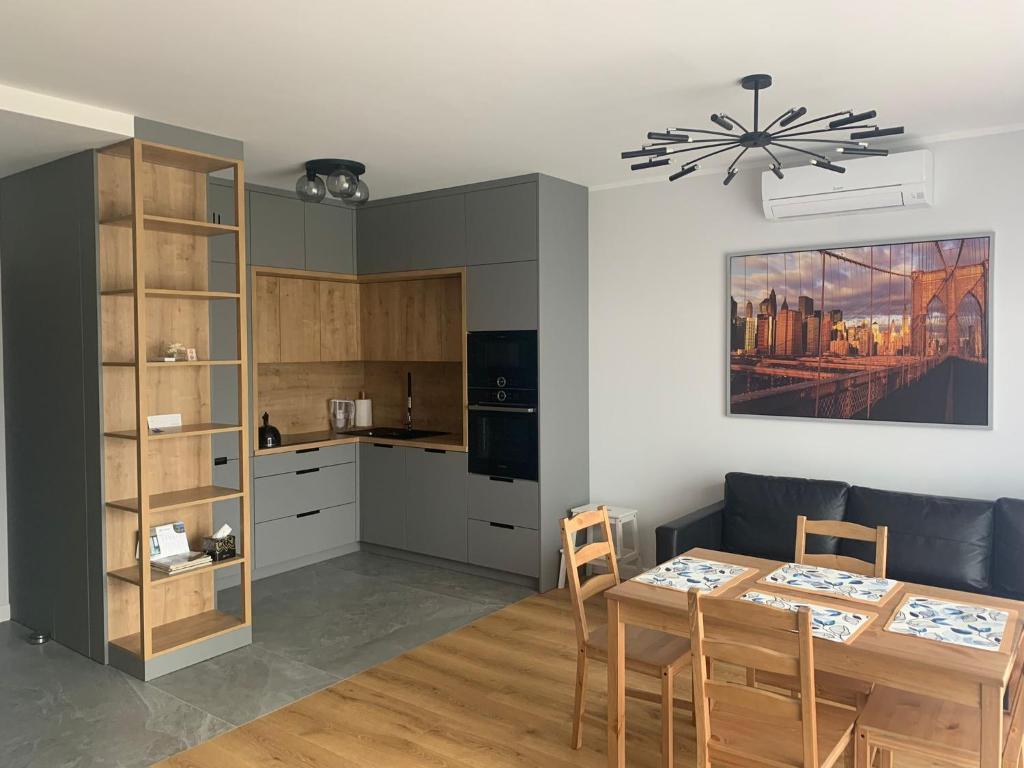 a kitchen and dining room with a table and chairs at Apartament Hebanowa in Swarzędz