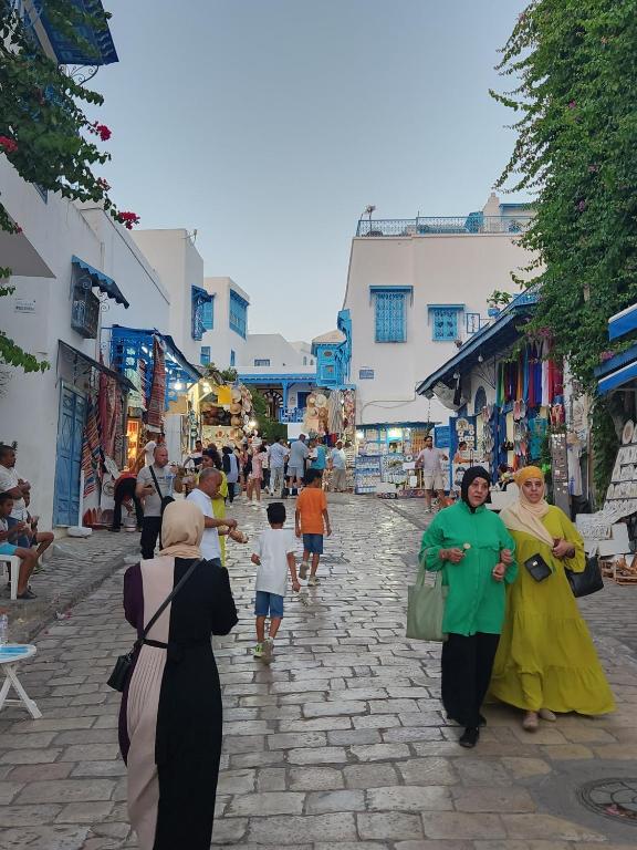 a group of people walking down a street at La maison 4 puits in Sidi Bou Saïd