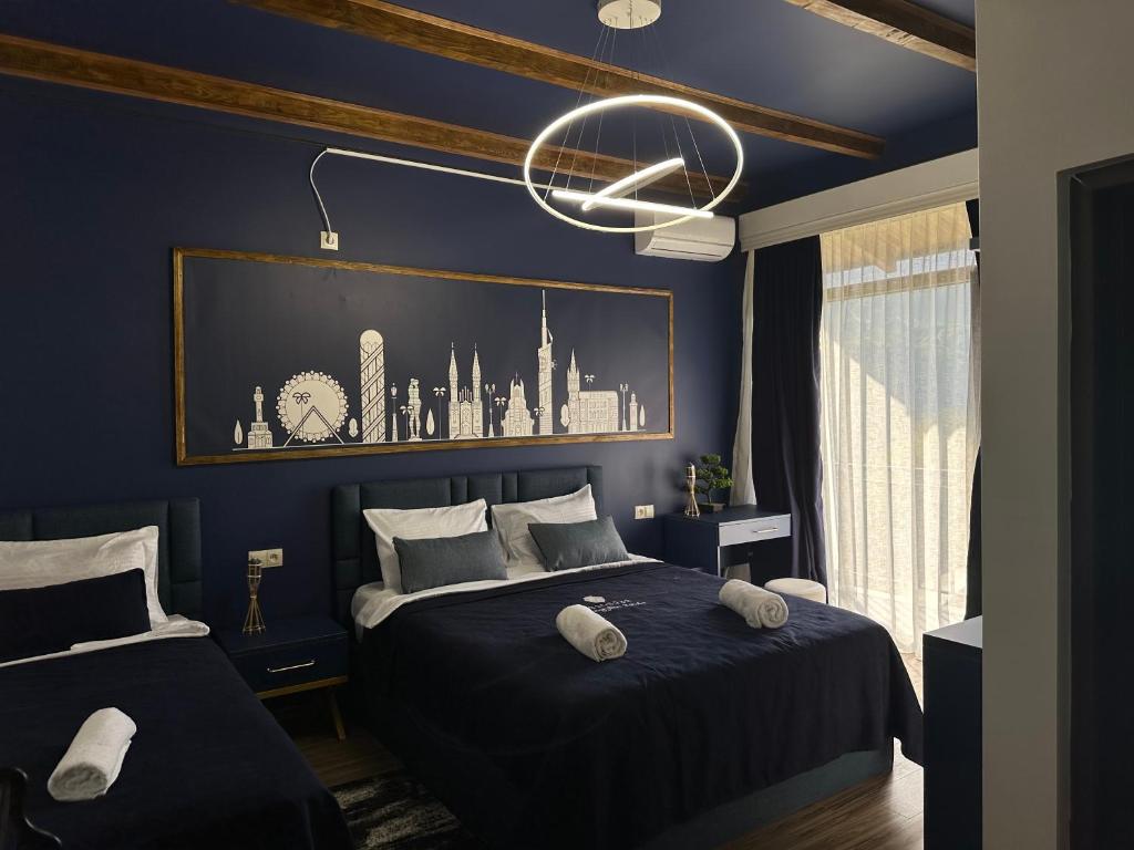 a blue bedroom with a bed and a chandelier at Pesvebi Design Hotel and Cellar in Borjomi