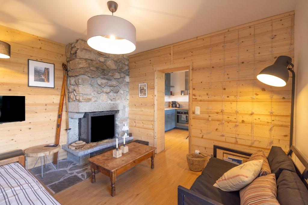 a living room with a stone fireplace in a house at St Gervais Les Bains - Mont Blanc in Saint-Gervais-les-Bains
