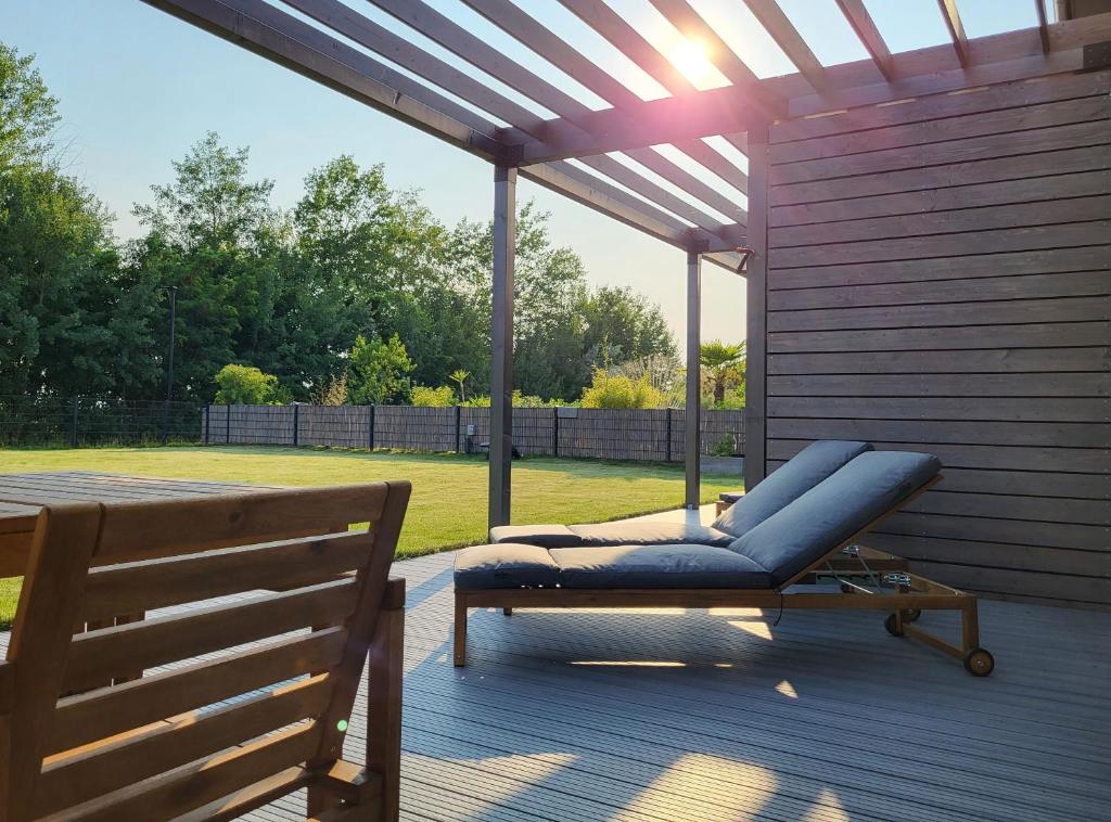 a blue reclining chair under a pergola on a deck at Ferienhaus Schlossterrassen 4a in Pouch