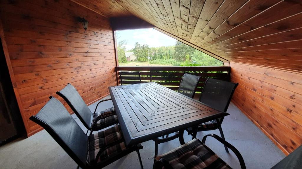 una mesa y sillas en una cabaña con ventana en Agro Karasiewo 