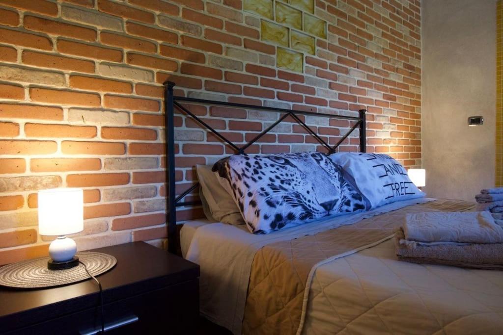 a bed in a room with a brick wall at CASA EVA in Celano