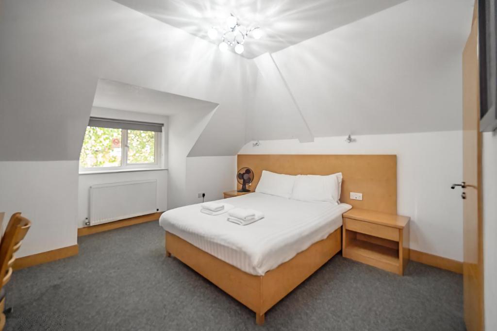 um quarto com uma cama grande e uma janela em Flexistay Aparthotel Sutton em Sutton