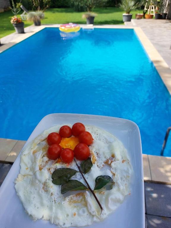 Un plato de comida en una mesa junto a una piscina. en Villa D Blagaj, en Blagaj