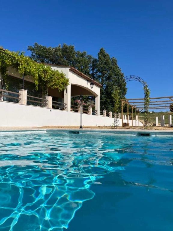 une piscine d'eau en face d'un bâtiment dans l'établissement Charmante maison avec piscine, à Artignosc-sur-Verdon