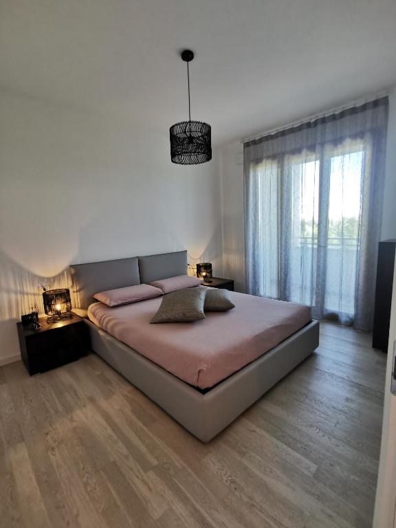 a bedroom with a large bed and a large window at La casa di Greta in Monza
