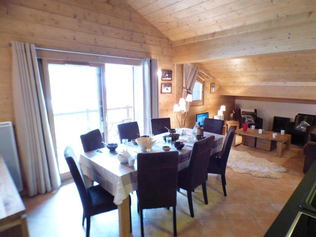 ein Esszimmer mit einem Tisch und Stühlen sowie einem großen Fenster in der Unterkunft Appartement Les Saisies, 4 pièces, 7 personnes - FR-1-594-87 in Hauteluce