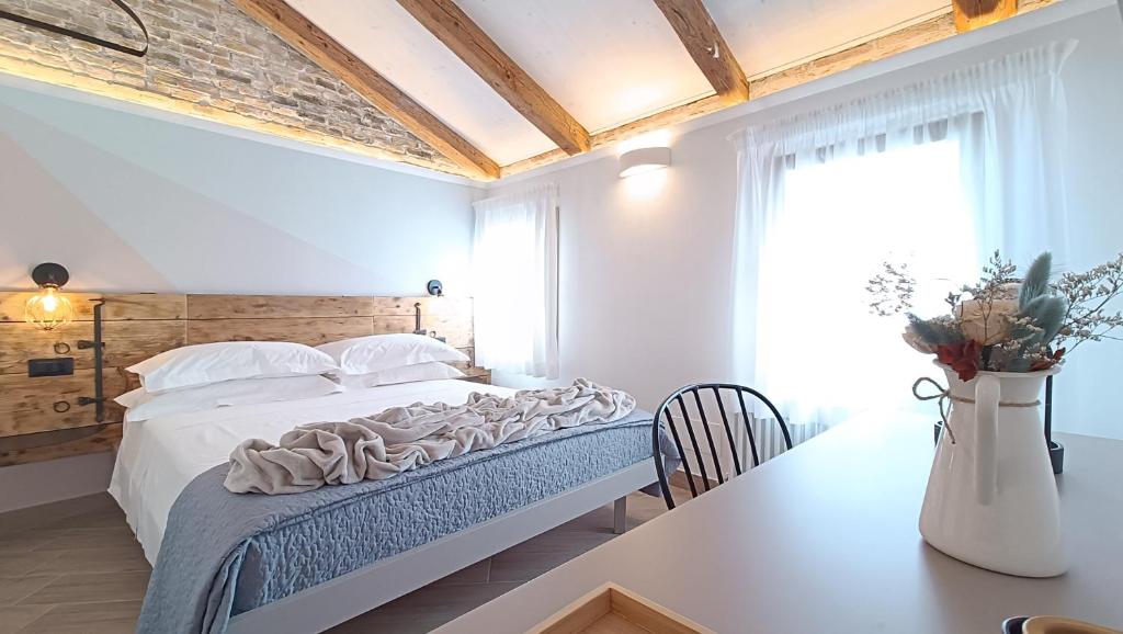 a white bedroom with a bed and a table at Casa Cuccagna Chioggia - Vista Canal Vena in Chioggia