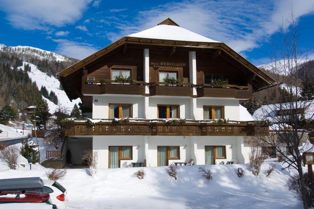 una casa en la nieve con un coche aparcado delante en Appartments Bergland en Bad Kleinkirchheim