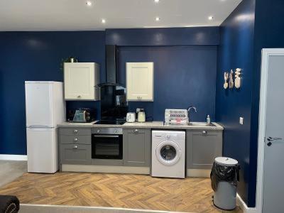 a kitchen with a washing machine and a refrigerator at Apartments on Albert Road with free parking in Blackpool