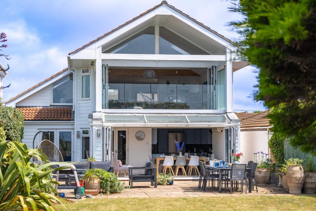 una casa con una gran ventana a un patio en High Tide, en Milford on Sea