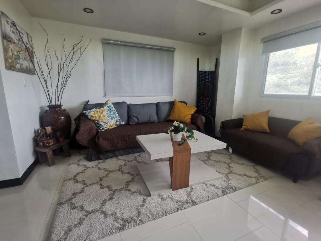 ein Wohnzimmer mit einem Sofa und einem Couchtisch in der Unterkunft 7th Heavens Vacation Home in Banaue