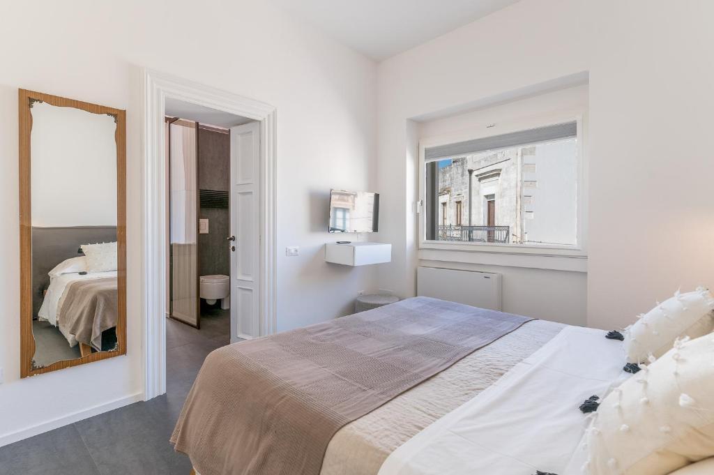 a bedroom with a large bed and a mirror at Arya Nobile Dimora in Carovigno