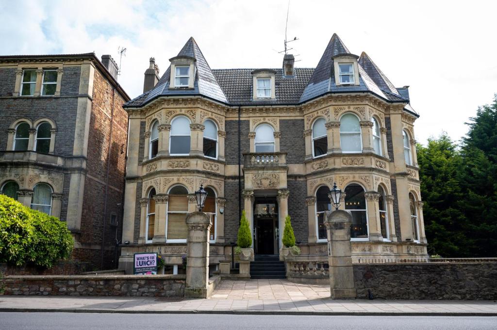 une grande maison en briques avec un panneau en face de celle-ci dans l'établissement Channings Hotel by Greene King Inns, à Bristol