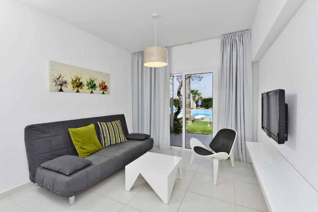 a living room with a couch and a tv at Mon Repos Hotel in Ayia Napa