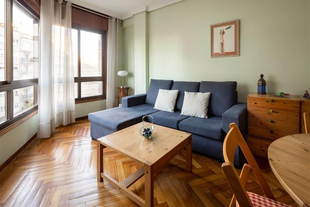 uma sala de estar com um sofá azul e uma mesa em Apartamento Centro de Vigo con Paking gratuito em Vigo