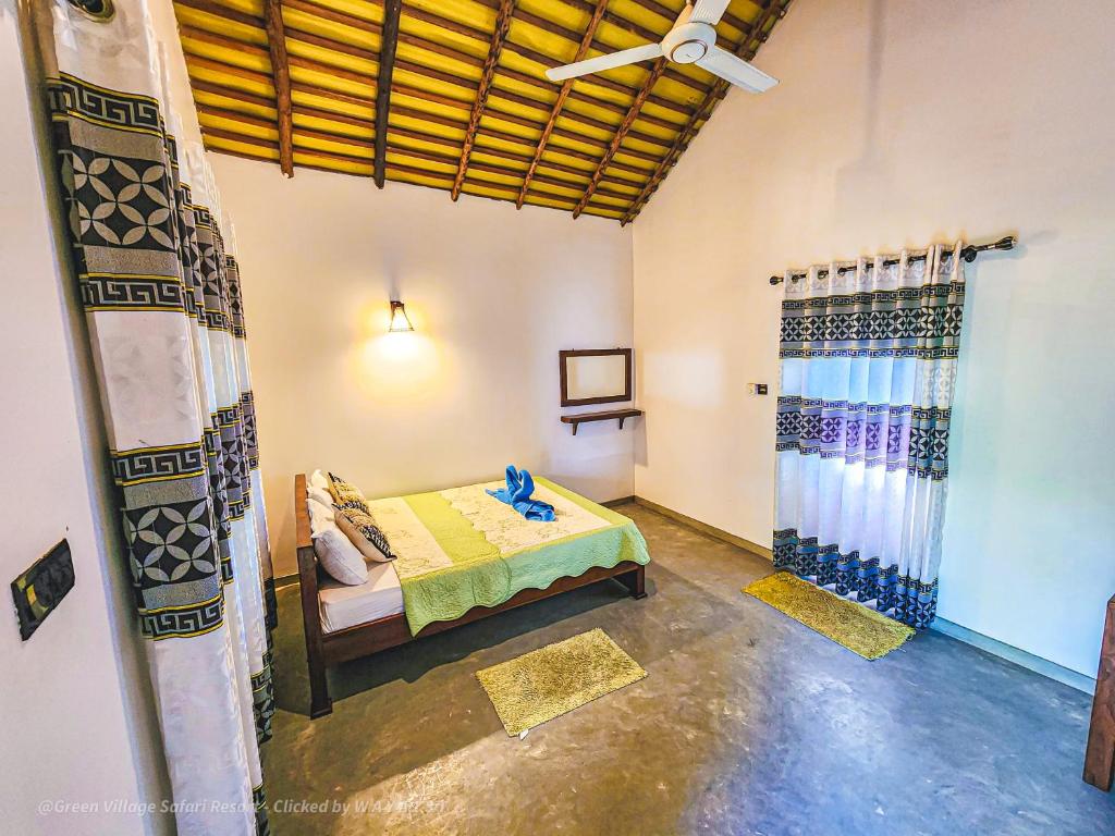 een kamer met een bed en een plafondventilator bij Green Village Safari Resort in Udawalawe