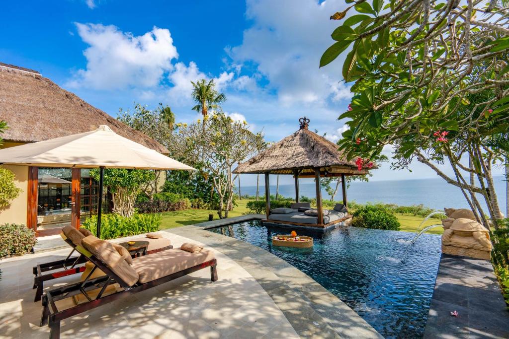 een overloopzwembad met een prieel naast een resort bij AYANA Villas Bali in Jimbaran