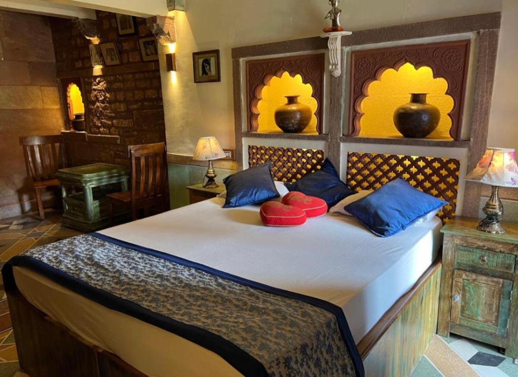 a bedroom with a large bed with blue and red pillows at Banaji Heritage Haveli in Jodhpur