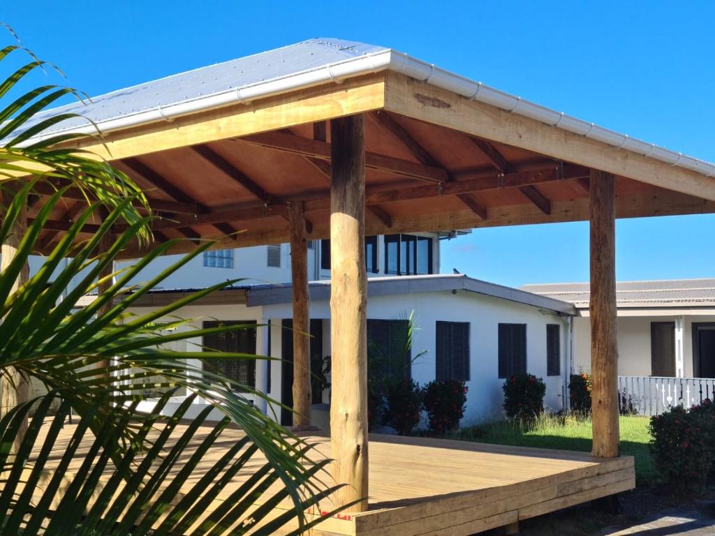 a wooden pergola in front of a house at The Ideal Bed & Breakfast in Nadi