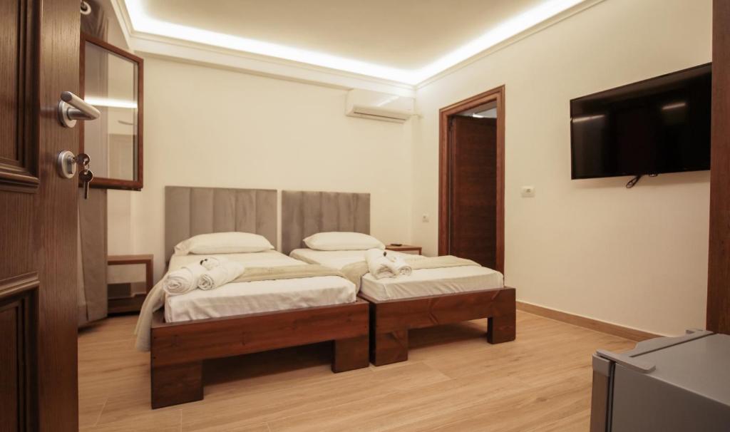 Habitación con 2 camas individuales y TV. en Vila Fatos Qama en Berat