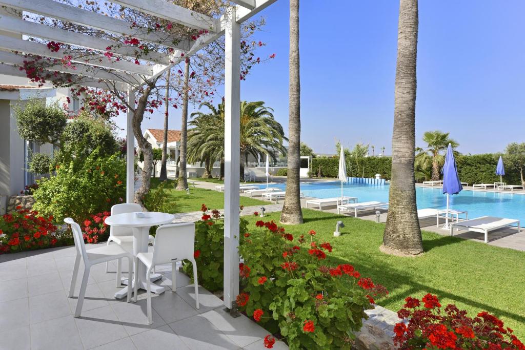 a patio with a table and chairs and a pool at Mon Repos Hotel in Ayia Napa