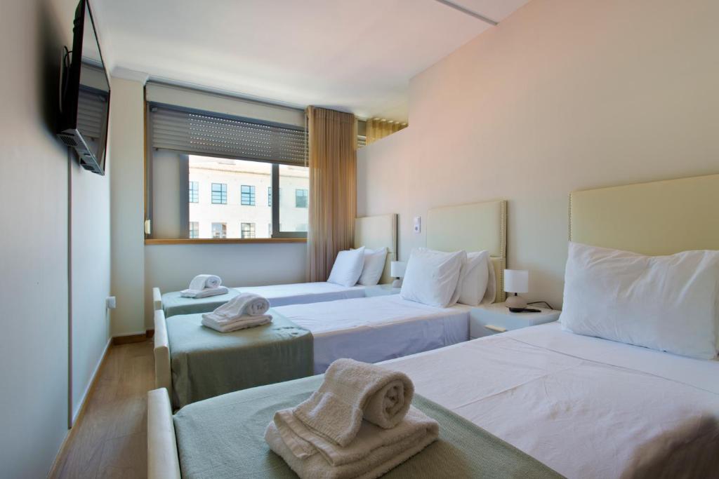 ポルトにあるストゥディオ ポルト ソラーのベッド2台とテレビが備わるホテルルームです。