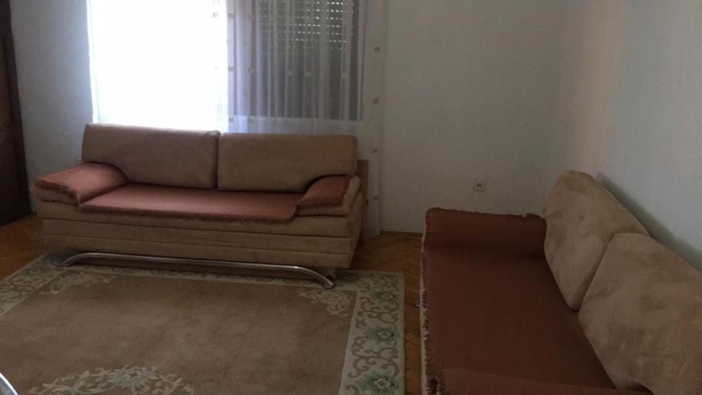 a living room with a couch and a window at Central Center Peja in Peje