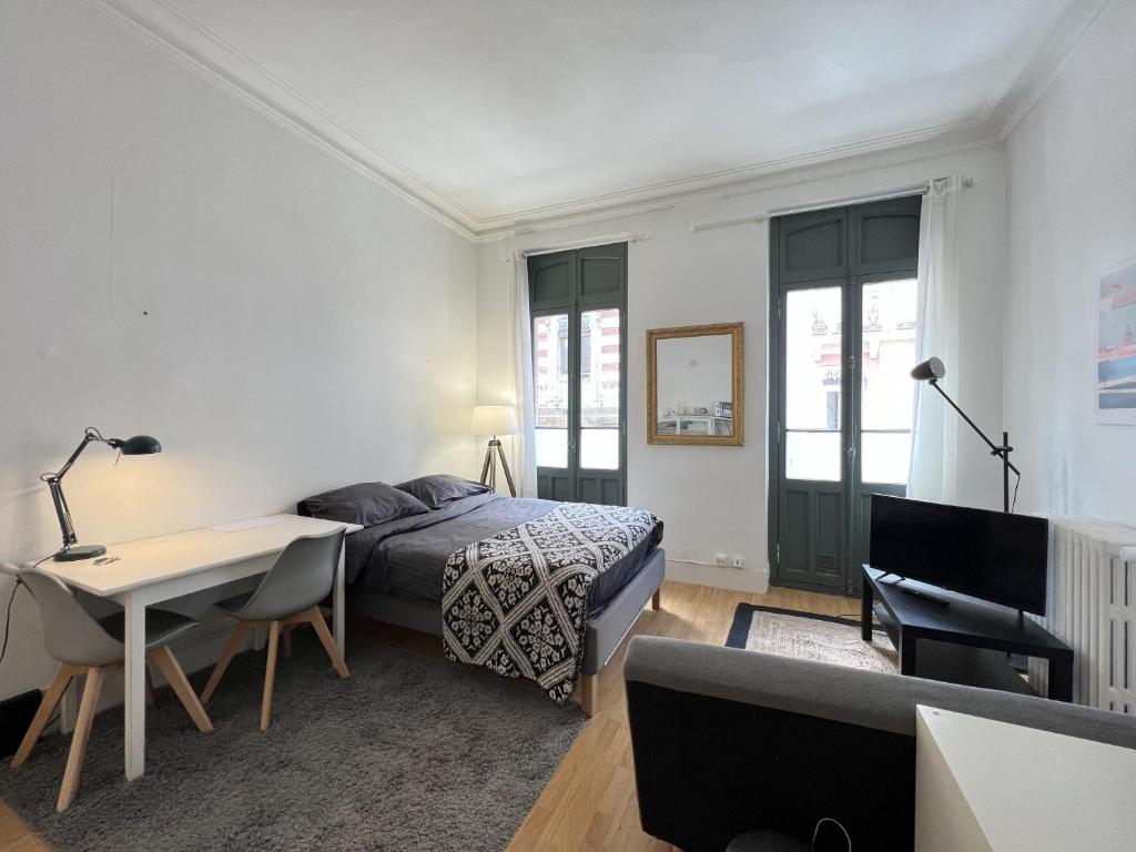 1 dormitorio con cama, escritorio y sofá en Le Relax - charmant studio proche Metro & Gare, en Toulouse