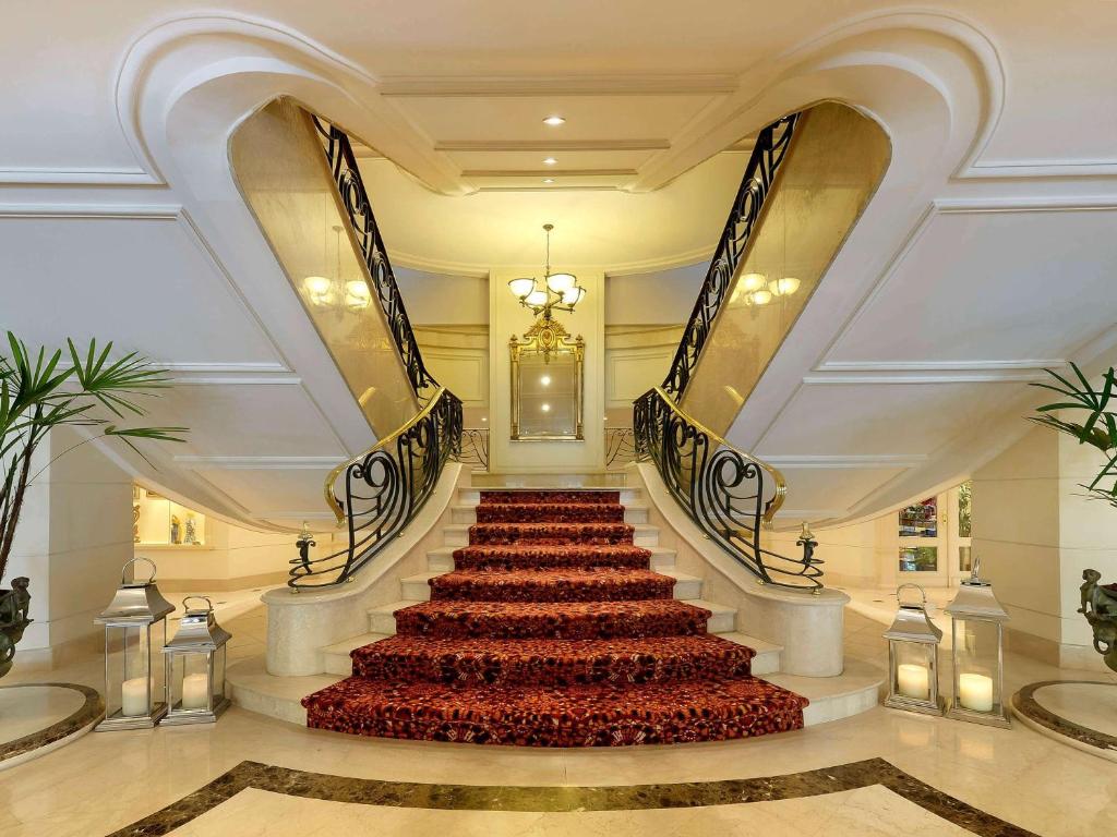 a staircase in a building with a red carpet at Grand Mercure Sao Paulo Ibirapuera in Sao Paulo