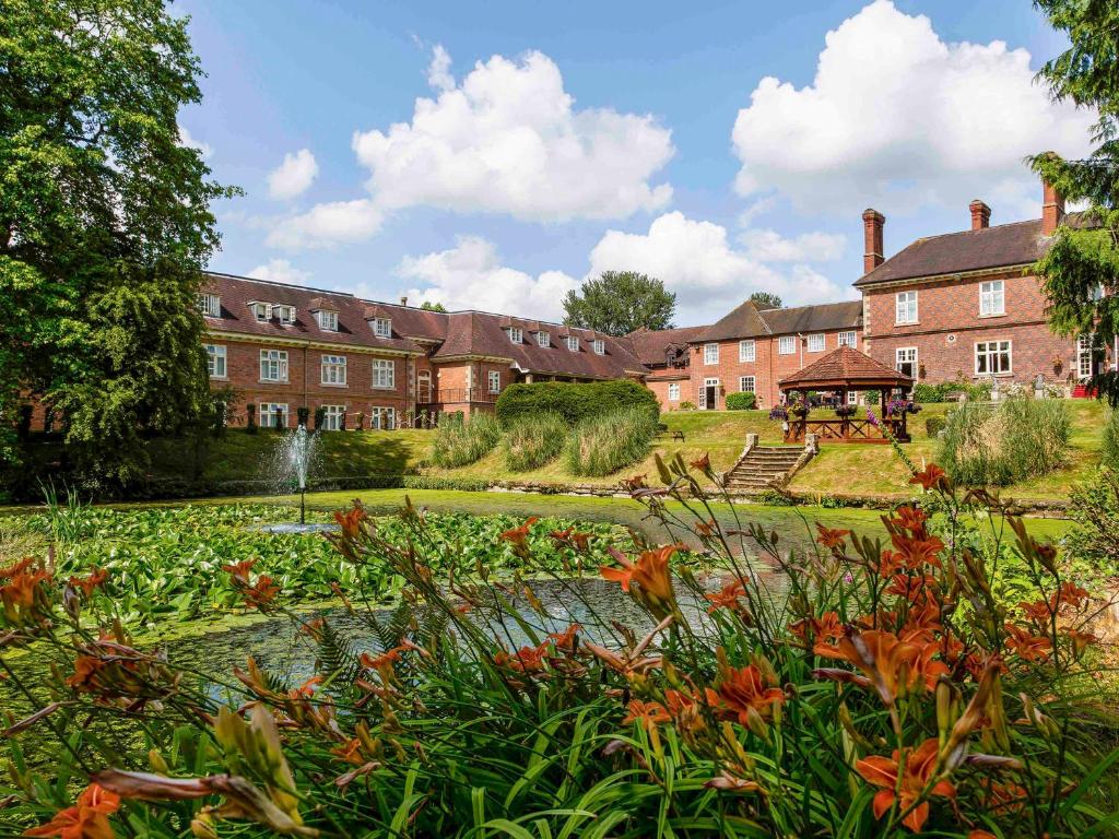 a building with a garden in front of it at Mercure Shrewsbury Albrighton Hall Hotel & Spa in Shrewsbury