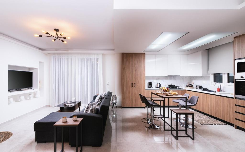 a living room and kitchen with a couch and chairs at Athena Home South Crete in Kapparianá