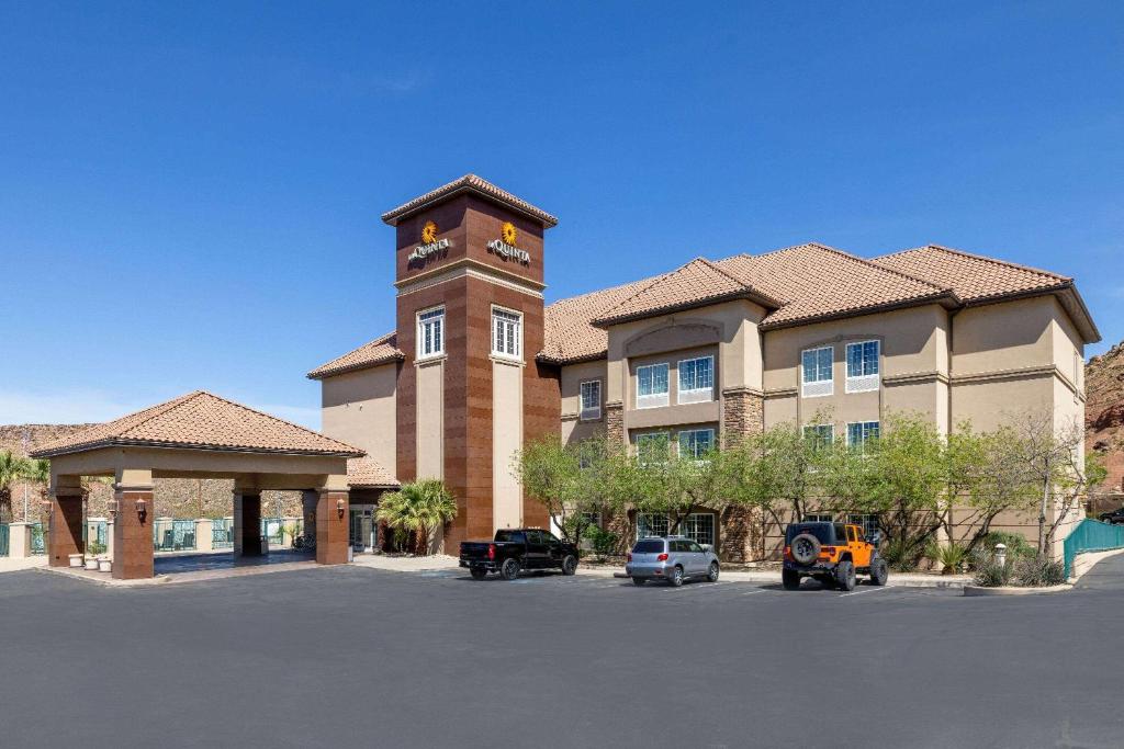 a large building with a clock tower in a parking lot at La Quinta by Wyndham St. George in St. George